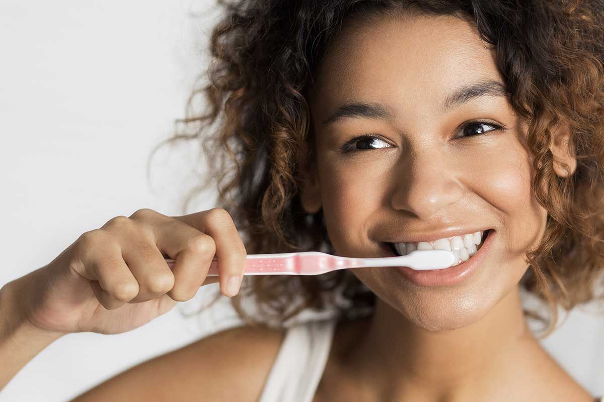 Woman practicing holiday dental care by brushing her teeth