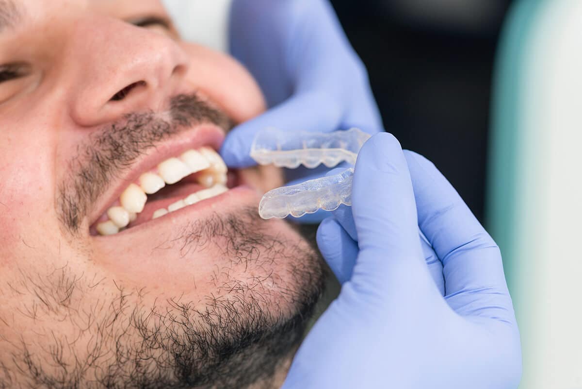 a man asking what is a periodontist while getting fitted for a retainer